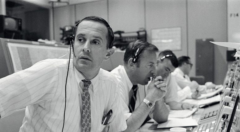 CAPCOM Charles Duke, with backup crewmen Jim Lovell and Fred Haise listening in during Apollo 11's descent CAPCOM Charles Duke, with backup crewmen Jim Lovell and Fred Haise listening in during Apollo 11's descent