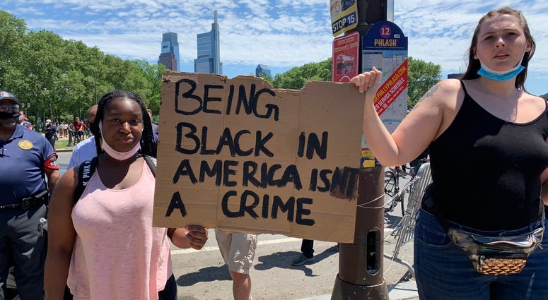 A pair of demonstrators holding a sign at the Philadelphia Museum or Art Saturday afternoon. The planned protests began peacefully, but erupted into violence after marchers left the Art Museum. A pair of demonstrators holding a sign at the Philadelphia Museum or Art Saturday afternoon. The planned protests began peacefully, but erupted into violence after marchers left the Art Museum.