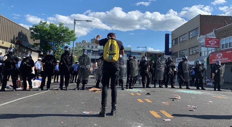 A line of police officers are confronted by a single protester in West Philly. A line of police officers are confronted by a single protester in West Philly.