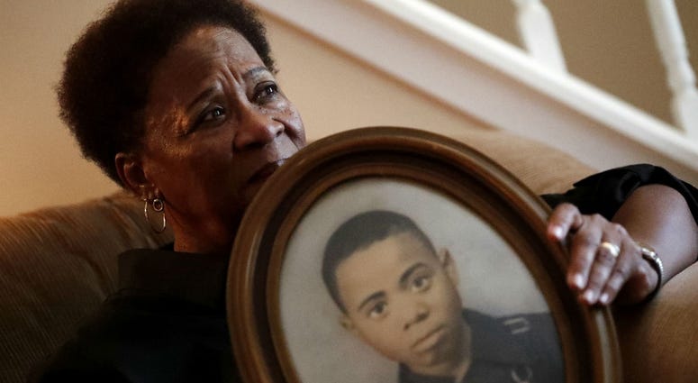 In this Aug. 9, 2018 photo, Eberlene King poses with a photograph of her brother William Roy Prather when he was about 15-years-old at her home in Doraville, Ga. In this Aug. 9, 2018 photo, Eberlene King poses with a photograph of her brother William Roy Prather when he was about 15-years-old at her home in Doraville, Ga.