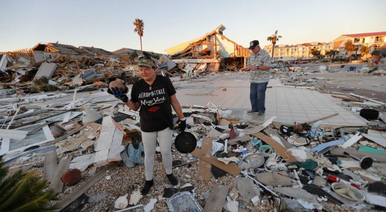 Lavonia Fortner helps her father-in-law, John E. Fortner, search for memorabilia his wife collected, in the aftermath of Hurricane Michael in Mexico Beach, Fla., Saturday, Oct. 13, 2018.