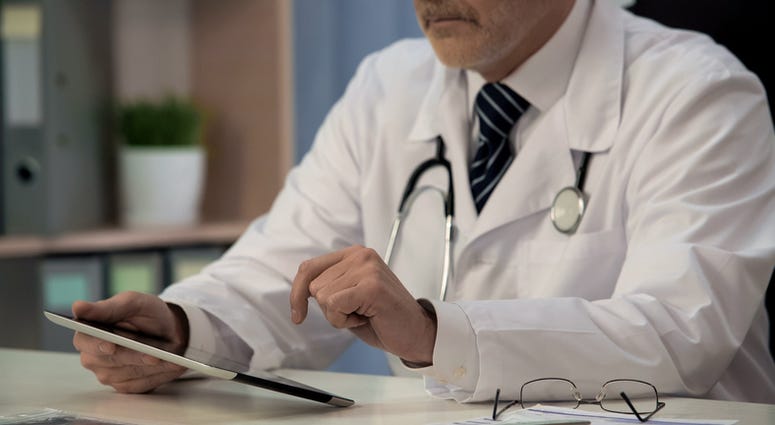 Doctor reading a tablet.