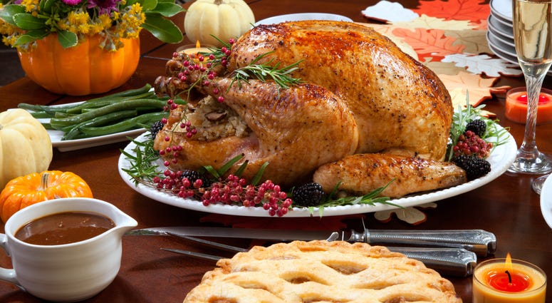 Roasted pepper turkey for Thanksgiving, garnished with pink pepper, blackberry, and fresh rosemary twigs on a dinner table decorated with mini pumpkins, beans, carrots, baked potato, pie, cranberry relish, gravy, flowers, candles, and flutes of champagne. Roasted pepper turkey for Thanksgiving, garnished with pink pepper, blackberry, and fresh rosemary twigs on a dinner table decorated with mini pumpkins, beans, carrots, baked potato, pie, cranberry relish, gravy, flowers, candles, and flutes of champagne.