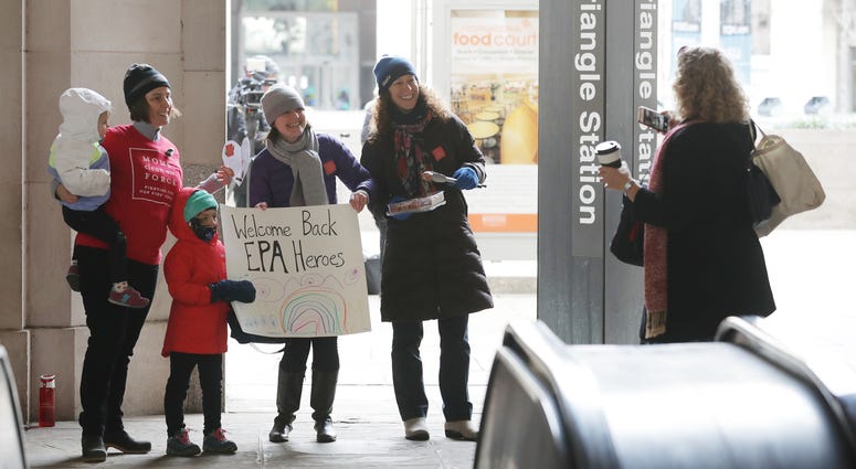 Moms Clean Air Force activists (from left) Liz Brandt, her daughters Natalia, 3, and Valencia Bednar, 5; Martha Roberts and Molly Rauch pose for a while welcoming EPA employees back to work outside a metro station, Jan. 28, 2019 in Washington. Moms Clean Air Force