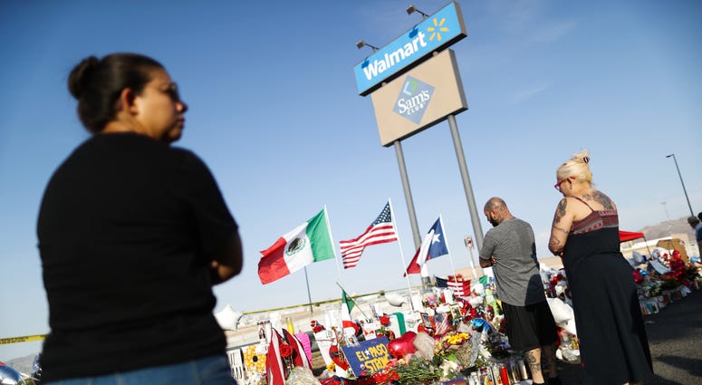 People gather at a makeshift memorial honoring victims outside Walmart, near the scene of a mass shooting which left at least 22 people dead, on August 7, 2019 in El Paso, Texas. Vigil outside El Paso Walmart after shooting