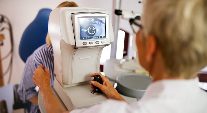 An eye doctor giving a test. An eye doctor giving a test.