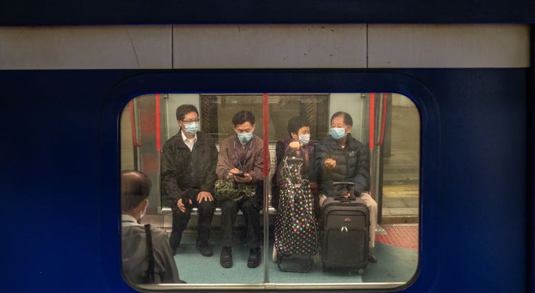 Passengers wearing protective masks wait on a train ahead of departure at the Lo Wu MTR station, where one of the border checkpoints government announced to be shutdown, on February 3, 2020 in Hong Kong, China. Passengers wearing protective masks wait on a train ahead of departure at the Lo Wu MTR station, where one of the border checkpoints government announced to be shutdown, on February 3, 2020 in Hong Kong, China.