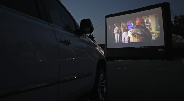 Attendees watch the movie "The Goonies" at a pop-up drive-in theatre built in the parking lot at the Broadway Commons on May 21, 2020 in Hicksville, New York. Drive-in movie theater