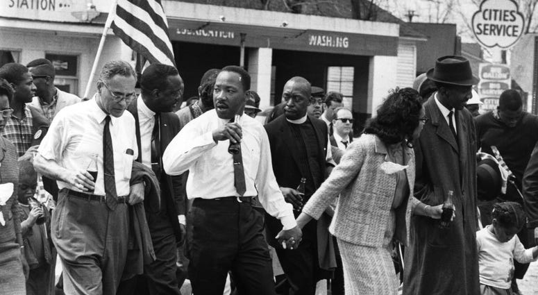 Martin Luther King, Jr. and his wife Coretta Scott King lead a civil rights march from Selma, Alabama, to the state capital in Montgomery. On the left (holding bottle) is American diplomat Ralph Bunche, March 1965. Martin Luther King, Jr.