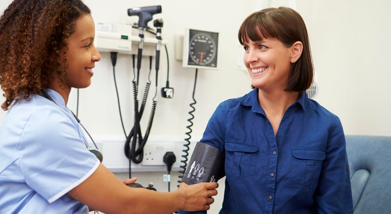 A woman getting her blood pressure checked. A woman getting her blood pressure checked by a doctor.