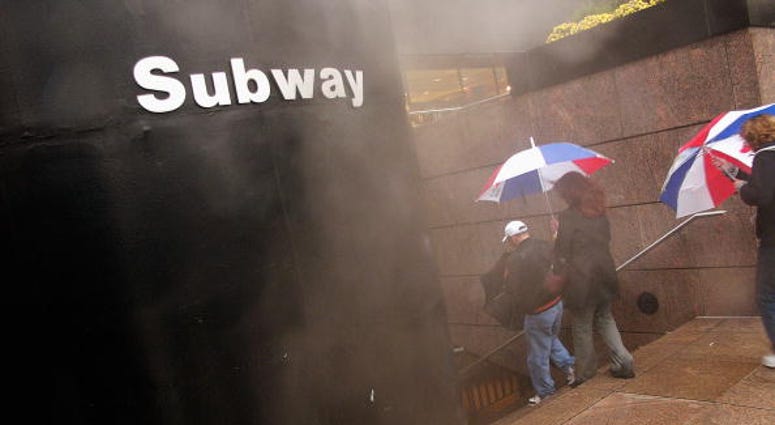 People enter a subway station on a wet and cold afternoon November 12, 2004 in New York City. New York City subway