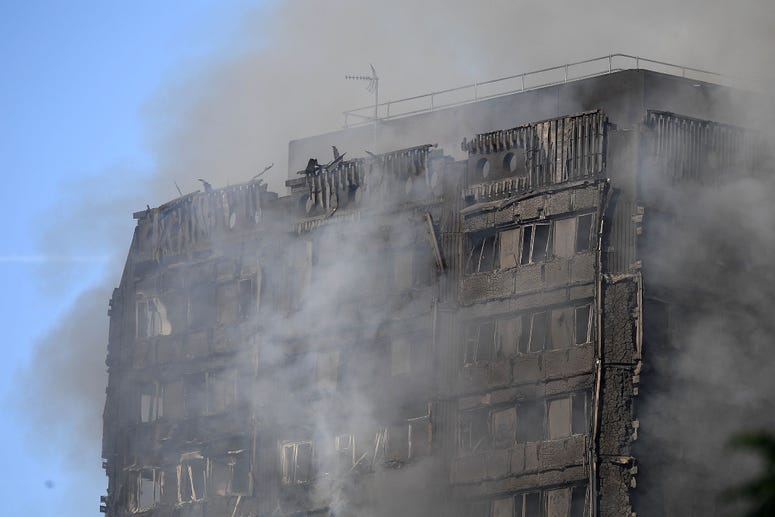 Smoke rises after a huge fire engulfed the 24 storey residential Grenfell Tower block in Latimer Road, West London in the early hours of this morning on June 14, 2017 in London, England. Grenfell Tower fire