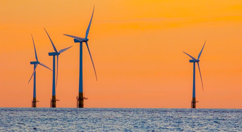 Offshore wind farm energy turbines at dawn.