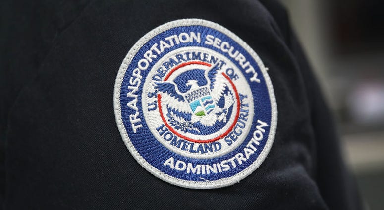 A patch is seen on the jacket of a Transportation Security Administration official as he works at the automated screening lanes funded by American Airlines. TSA
