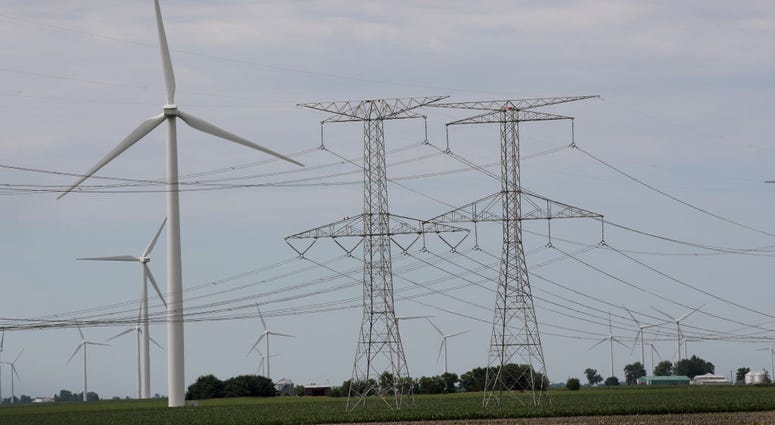 Power lines and power generating windmills rise above the rural landscape on June 14, 2018 near Dwight, Illinois. Power lines and power generating windmills
