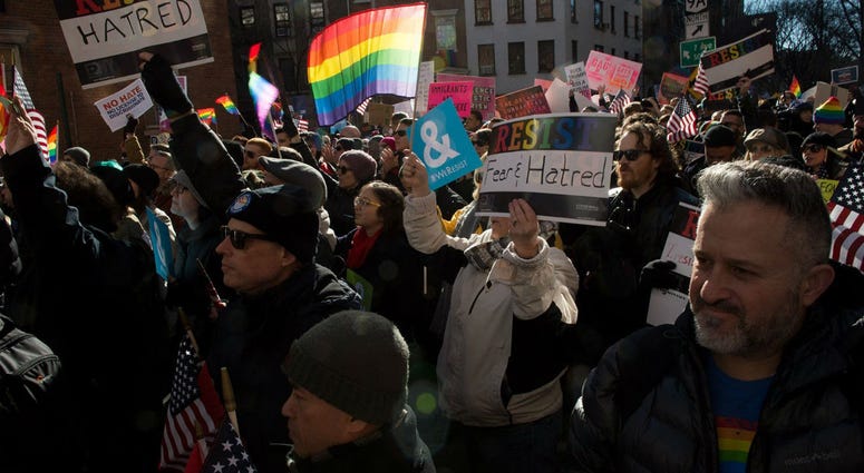 The Human Rights Campaign on Sunday called for the Trump administration not to go forward with a rollback of protections for transgender people, following a report in The New York Times on a draft proposal. People hold signs and flags at a rally