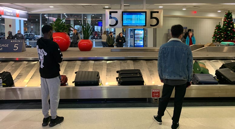 Travelers wait by the baggage claim at Philadelphia International Airport, on the busiest travel day of the year. Travelers wait by the baggage claim at Philadelphia International Airport.