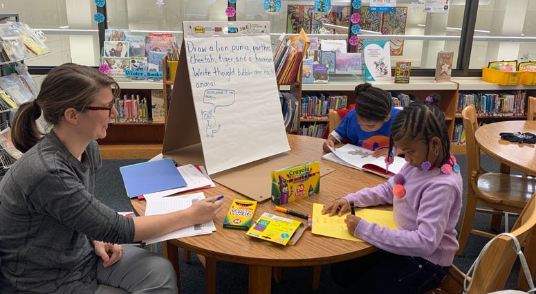 Megan Larson of the Free Library's Literacy Lab works with two young children to help them with their reading. Megan Larson of the Free Library's Literacy Lab works with two young children to help them with their reading.
