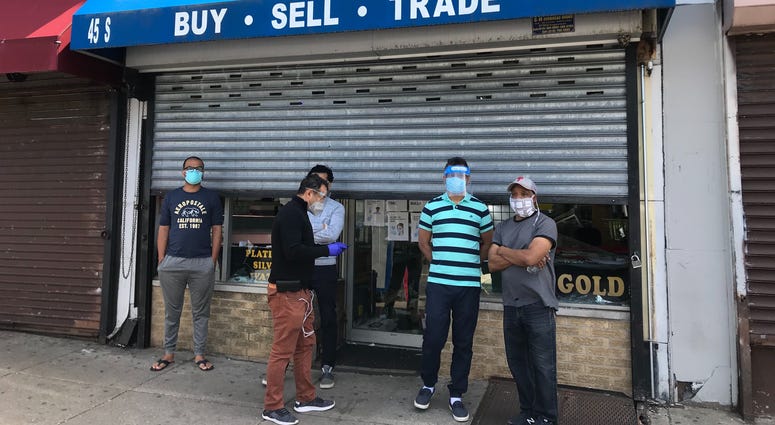 Men stand in front of MN Wireless, a 52nd Street business that got looted during the protests sparked by the death of George Floyd. Men standing in front of MN Wireless on 52nd Street