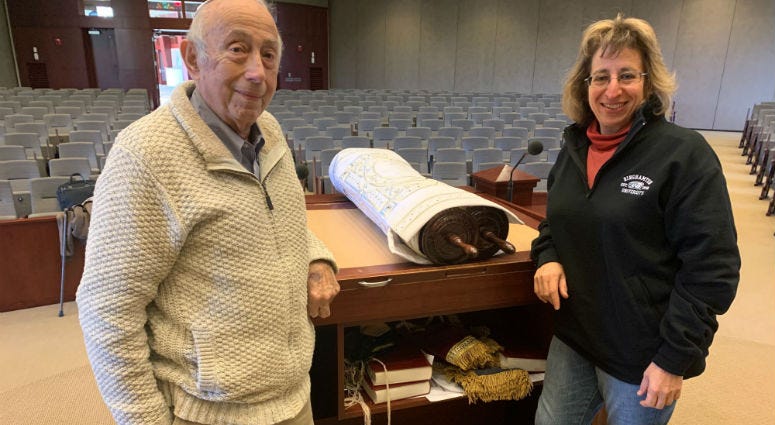 Fred Behrend with daughter Evelyn Behrend in front of a Holocaust-era Torah from the synagogue that was recently restored. Fred Behrend with daughter Evelyn Behrend.