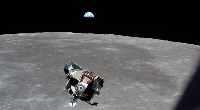 Astronaut Mike Collins captures Earth, the moon, the Eagle, and the edge of the Command Module's window in a single shot. Astronaut Mike Collins captures Earth, the moon, the Eagle, and the edge of the Command Module's window in a single shot.