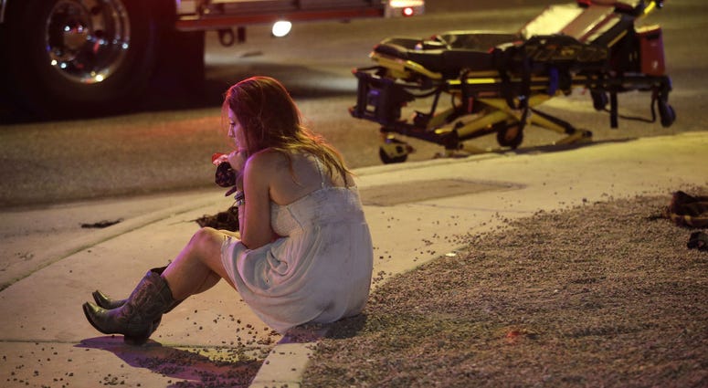 In this Oct. 2, 2017 file photo, a woman sits on a curb at the scene of a shooting outside a music festival on the Las Vegas Strip. It took 11 minutes for the gunman in the deadliest mass shooting in modern U.S. history to kill 58 people. In this Oct. 2, 2017 file photo, a woman sits on a curb at the scene of a shooting outside a music festival on the Las Vegas Strip. It took 11 minutes for the gunman in the deadliest mass shooting in modern U.S. history to kill 58 people.