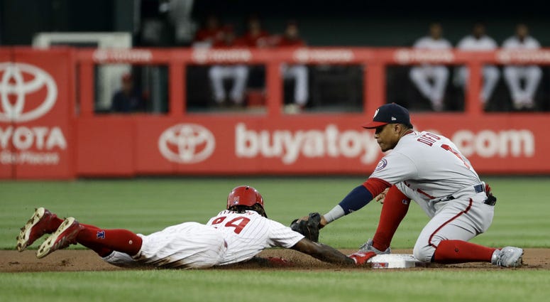 Philadelphia Phillies' Roman Quinn, left, dives safely back to second base under the tag from Washington Nationals shortstop Wilmer Difo on a pickoff attempt during the first inning of a baseball game, Wednesday, Aug. 29, 2018, in Philadelphia. Philadelphia Phillies' Roman Quinn, left, dives safely back to second base under the tag from Washington Nationals shortstop Wilmer Difo on a pickoff attempt during the first inning of a baseball game, Wednesday, Aug. 29, 2018, in Philadelphia.