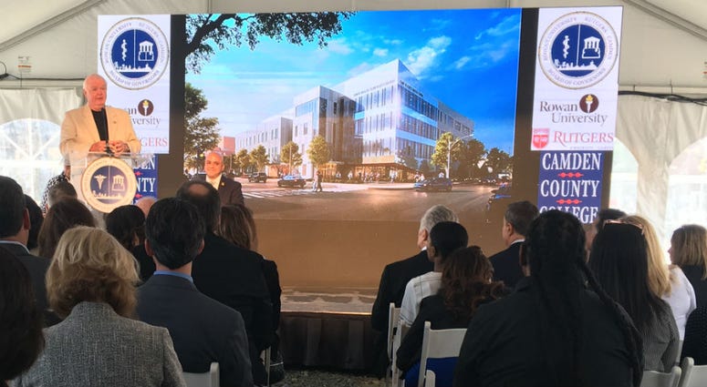 Rutgers President Robert Barchi is shown with an artist's rendering of new Health Sciences Center building.