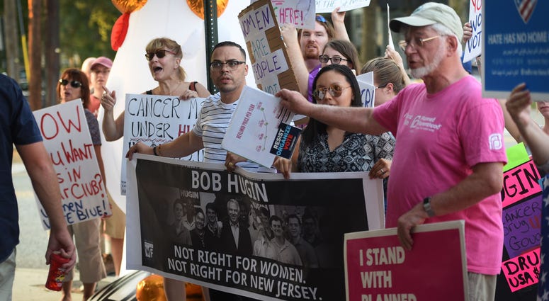 A group hold a pop-up protest outside of the Railyard Tavern in Fair Lawn on Aug. 6, 2018, where Bob Hugin, the Republican nominee, who is trying to unseat U.S. Sen. Bob Menendez in the November election, is holding a Girls Night Out fundraiser. New Jersey Senate protest