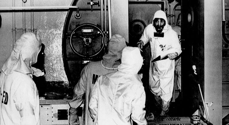 A Three Mile Island technician leans out of the No. 2 airlock, telling co-workers the room is free of radiation, March 1980. This was the first time anyone had entered the area since the partial meltdown a year before. Three Mile Island