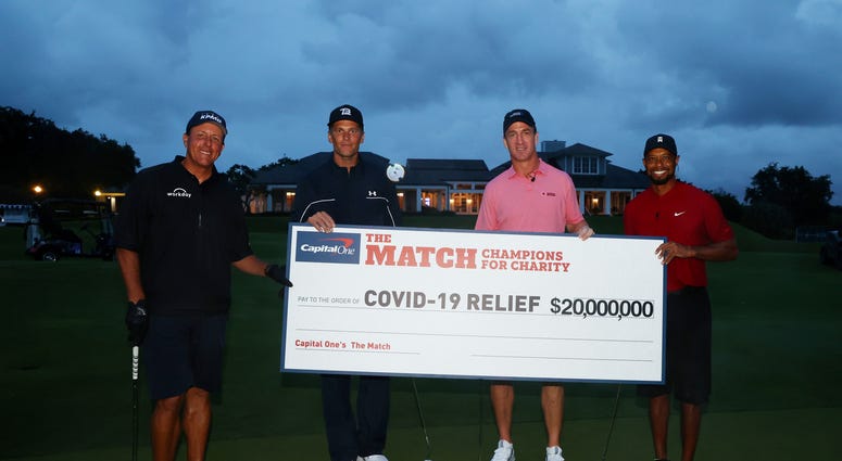 Tiger Woods and former NFL player Peyton Manning celebrate defeating Phil Mickelson and NFL player Tom Brady of the Tampa Bay Buccaneers on the 18th green during The Match: Champions for Charity. The Match-Champions for Charity