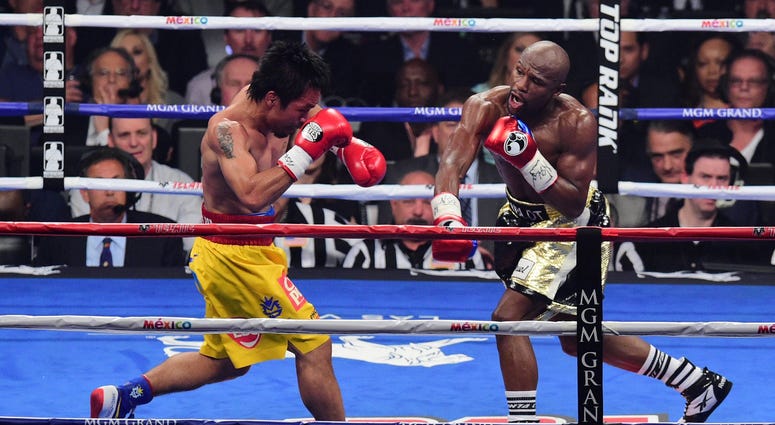 Floyd Mayweather (black/gold trunks) and Manny Pacquiao (yellow/red trunks) box during their world welterweight championship bout at MGM Grand Garden Arena. Mayweather won via unanimous decision. Mayweather / Pacquiao