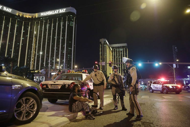 In this Oct. 1, 2017 file photo, police officers stand at the scene of a mass shooting near the Mandalay Bay resort and casino on the Las Vegas Strip, in Las Vegas. In this Oct. 1, 2017 file photo, police officers stand at the scene of a mass shooting near the Mandalay Bay resort and casino on the Las Vegas Strip, in Las Vegas.