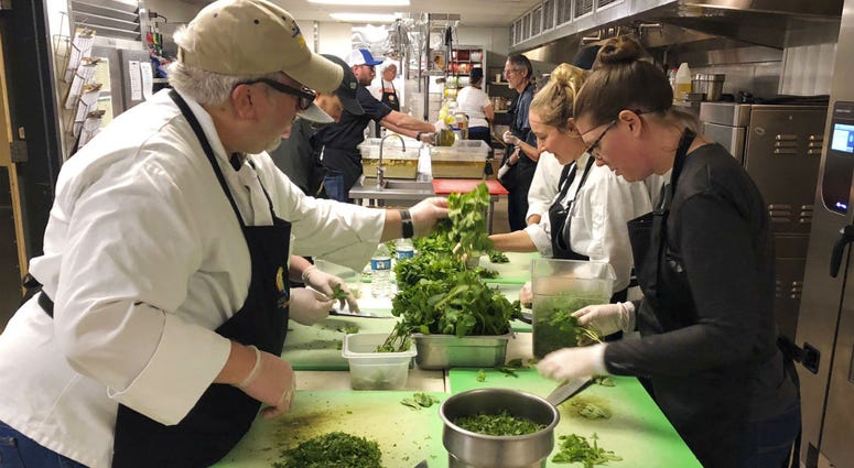 Michael Reining, left, and Chelsea Meddings, right, chop mint in preparation for a community Thanksgiving meal for survivors of the deadly Camp Fire in Northern California, on the campus of California State University, in Chico, Calif. Michael Reining, left, and Chelsea Meddings, right, chop mint in preparation for a community Thanksgiving meal for survivors of the deadly Camp Fire in Northern California, on the campus of California State University, in Chico, Calif.