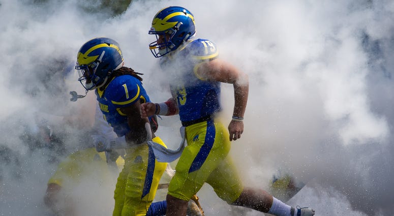 Delaware brings a 3-1 record into Saturday's battle with Pitt. Members of the University of Delaware Blue Hens running onto the football field.