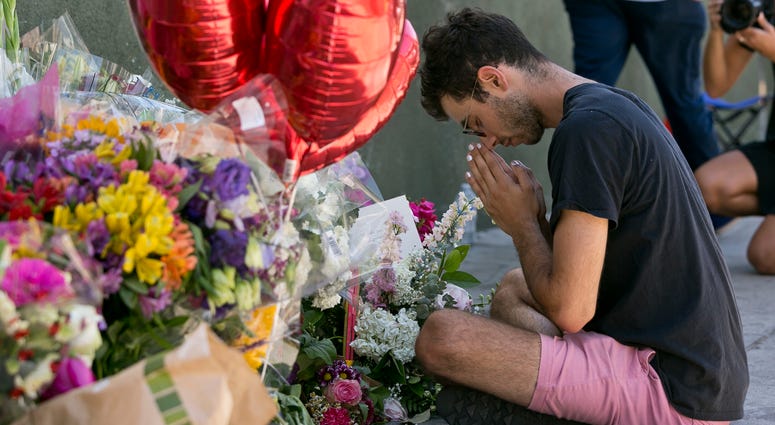 Paolo Singer, 27, a Silver Lake resident, prays at a makeshift memorial of flowers, candles and notes growing on the sidewalk outside the Silver Lake Trader Joe's store in Los Angeles, Monday, July 23, 2018. Paolo Singer, 27, a Silver Lake resident, prays at a makeshift memorial of flowers, candles and notes growing on the sidewalk outside the Silver Lake Trader Joe's store in Los Angeles, Monday, July 23, 2018.