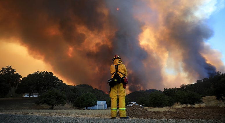 A tower of smoke pours from Cow Mountain as Burney, California firefighter Bob May keeps a watch on surrounding vegetation for spot fires during a wildfire off Scotts Valley Road, Thursday, Aug. 2, 2018, near Lakeport, Calif. A tower of smoke pours from Cow Mountain as Burney, California firefighter Bob May keeps a watch on surrounding vegetation for spot fires during a wildfire off Scotts Valley Road, Thursday, Aug. 2, 2018, near Lakeport, Calif.
