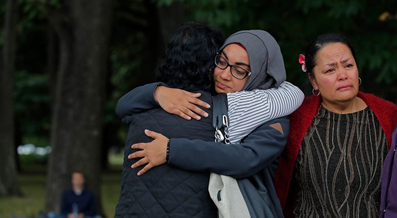 Mourners hug after paying their respects to the victims near the Masjid Al Noor mosque in Christchurch, New Zealand, Monday, March 18, 2019. A steady stream of mourners paid tribute at makeshift memorial to the 50 people slain by a gunman at two mosques i Mourners hug after paying their respects to the victims near the Masjid Al Noor mosque in Christchurch, New Zealand, Monday, March 18, 2019. A steady stream of mourners paid tribute at makeshift memorial to the 50 people slain by a gunman at two mosques i