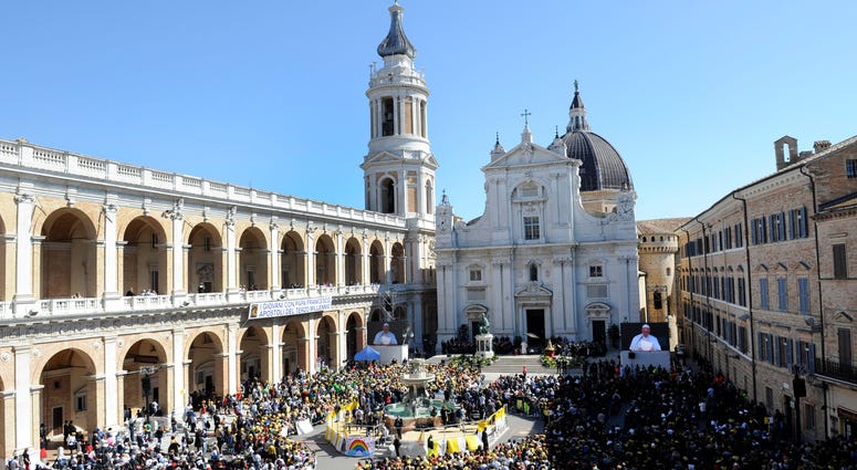 Pope Francis seen on a giant screen at right, celebrates Mass outside Loreto's cathedral, central Italy, Monday, March 25, 2019. Pope Francis seen on a giant screen at right, celebrates Mass outside Loreto's cathedral, central Italy, Monday, March 25, 2019.