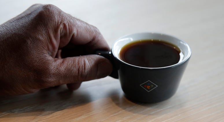 Klatch Coffee owner Bo Thiara holds a cup of Elida Natural Geisha coffee at his shop in San Francisco, Wednesday, May 15, 2019. The California cafe is brewing up what it calls the world's most expensive coffee - at $75 a cup.