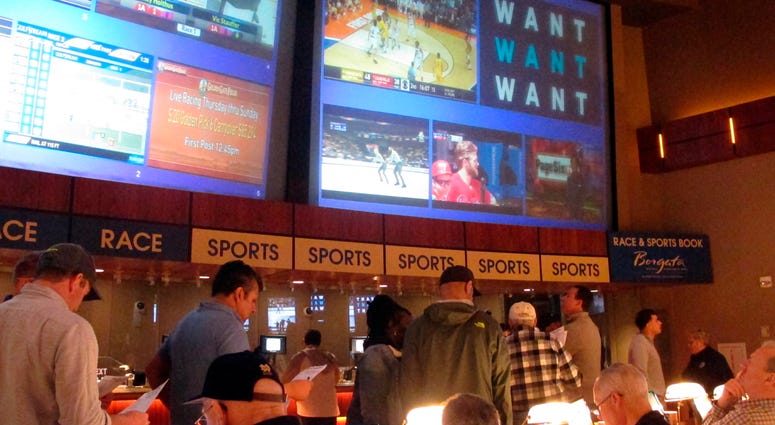 FILE - In this March 21, 2019, file photo, gamblers line up to place bets on the NCAA men's college basketball tournament at the Borgata casino in Atlantic City N.J. This is the first March Madness tournament since legal gambling expanded last year in the U.S. The spread of legalized sports betting is largely following regional boundaries.