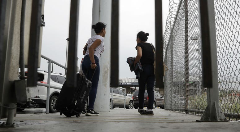 In this June 20, 2018, file photo, sisters from Guatemala seeking asylum, cross a bridge to a port of entry in to the United States from Matamoros, Mexico, in Brownsville, Texas. In this June 20, 2018, file photo, sisters from Guatemala seeking asylum, cross a bridge to a port of entry in to the United States from Matamoros, Mexico, in Brownsville, Texas.