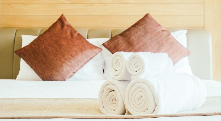White bath towel on bed decoration in bedroom interior White bath towel on bed decoration in bedroom interior