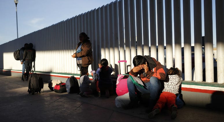 A migrant sits with his children as they wait to hear if their number is called to apply for asylum in the United States, at the border, Friday, Jan. 25, 2019, in Tijuana, Mexico. A migrant sits with his children as they wait to hear if their number is called to apply for asylum in the United States, at the border, Friday, Jan. 25, 2019, in Tijuana, Mexico.