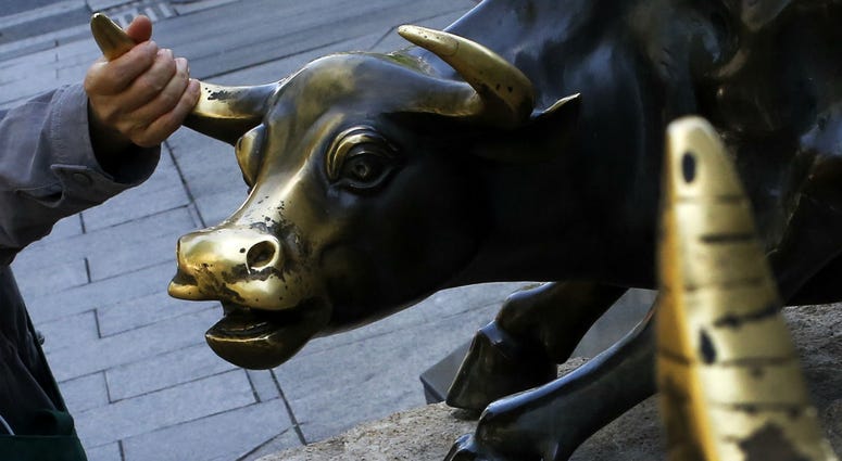 A woman touches a bull statue on display outside a bank in Beijing, Monday, May 6, 2019. A woman touches a bull statue on display outside a bank in Beijing, Monday, May 6, 2019.