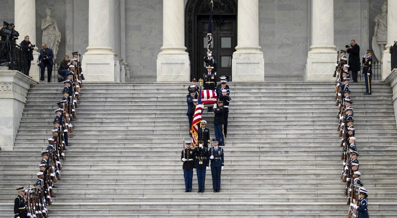 A U.S. military honor guard carries the flag-draped casket of the late former President George H.W. Bush down the steps of the U.S. Capitol, December 5, 2018 in Washington, DC. A U.S. military honor guard carries the flag-draped casket of the late former President George H.W. Bush down the steps of the U.S. Capitol, December 5, 2018 in Washington, DC.