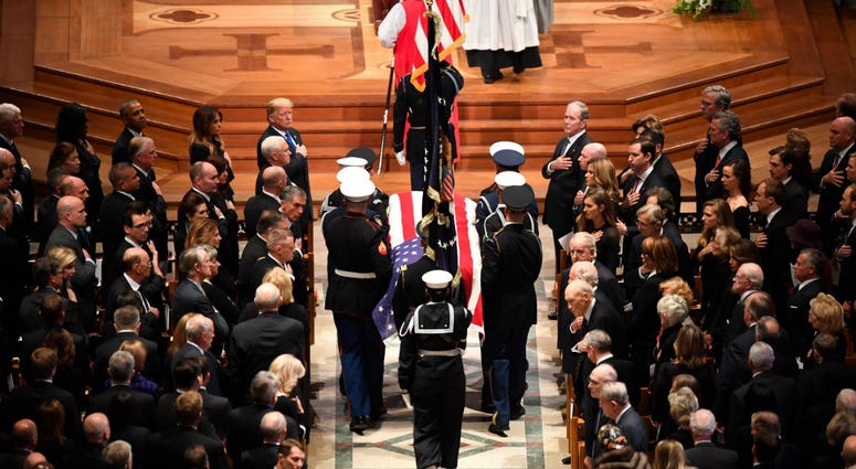 The flag-draped casket of former President George H.W. Bush is carried by a military honor guard during a State Funeral at the National Cathedral, Wednesday, Dec. 5, 2018, in Washington. The flag-draped casket of former President George H.W. Bush is carried by a military honor guard during a State Funeral at the National Cathedral, Wednesday, Dec. 5, 2018, in Washington.