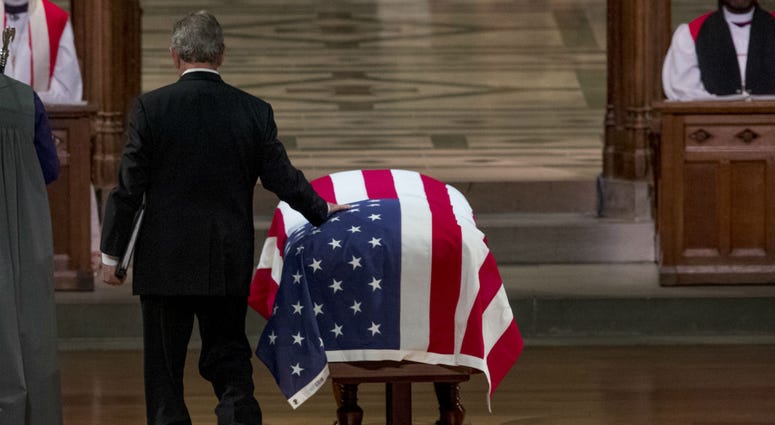 Former President George Bush touches the flag-draped casket of his father, former President George H.W. Bush, as he prepares to speak during his State Funeral at the National Cathedral, December 5, 2018 in Washington, DC. Former President George Bush touches the flag-draped casket of his father, former President George H.W. Bush, as he prepares to speak during his State Funeral at the National Cathedral, December 5, 2018 in Washington, DC.
