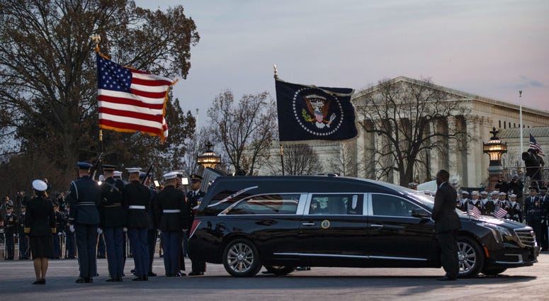 A joint services military honor guard removes the casket of former President George H.W. Bush from the hearse to carry it into the rotunda of the U.S. Capitol in Washington to lie in state, Monday, Dec. 3, 2018. A joint services military honor guard removes the casket of former President George H.W. Bush from the hearse to carry it into the rotunda of the U.S. Capitol in Washington to lie in state, Monday, Dec. 3, 2018.