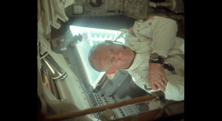 Buzz in the LM during its checkout en route to the Moon. He is on the left side of the cabin and is placing a pair of sunglasses in his jacket's arm pocket. Buzz in the LM during its checkout en route to the Moon. He is on the left side of the cabin and is placing a pair of sunglasses in his jacket's arm pocket.